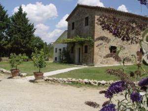 ein Steingebäude mit lila Blumen davor in der Unterkunft Ferienwohnung "La Taverna" in Umbertide