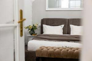 a bedroom with a bed with a brown headboard and white pillows at Romari apartment Братів Рогатинців 32 in Lviv