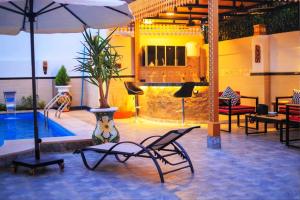 a patio with a pool and chairs and an umbrella at Hamed's House Luxor in Luxor
