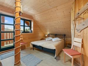 a bedroom in a log cabin with a bed and a chair at Chalet Quiet place Cabin by Interhome in Benešov nad Černou