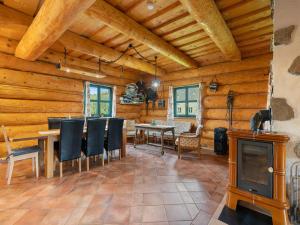a dining room with a table and a fireplace at Chalet Quiet place Cabin by Interhome in Benešov nad Černou