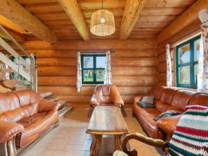 a living room with leather furniture in a log cabin at Chalet Srub Pohodář by Interhome in Benešov nad Černou