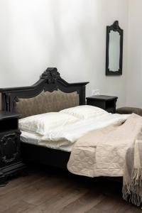a bedroom with a bed and two tables and a mirror at Romari Братів Рогатинців 32 in Lviv