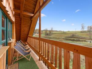 a porch with chairs and a view of a field at Chalet Quiet place Cabin by Interhome in Benešov nad Černou