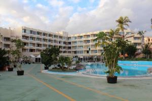a resort with a large swimming pool and palm trees at Casa LuLu in San Miguel de Abona