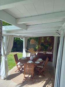 un patio avec une table et des chaises sous un pavillon dans l'établissement Lagon privé du Diamant, au Diamant
