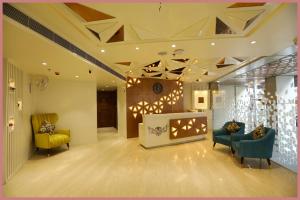 vestíbulo con 2 sillas y chimenea en Bhanumati Road Nilayam Palace Resort - Fully Air Hotel, en Puri