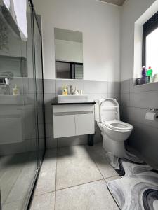 a bathroom with a toilet and a sink and a shower at Sunset Sucasa in Midrand