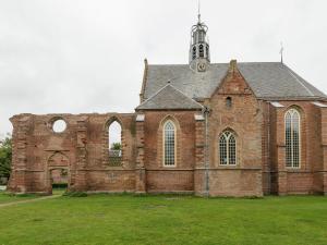 ein altes Backsteingebäude mit einem Turm auf einer Wiese in der Unterkunft Alluring Apartment in Bergen with Terrace, Garden and BBQ in Bergen + 33 Fotos