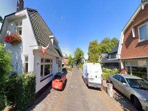 ein Auto, das vor einem Haus mit einem Anhänger parkt in der Unterkunft Alluring Apartment in Bergen with Terrace, Garden and BBQ in Bergen