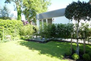 einen Hof mit einem Haus mit einem Baum und einem Gebäude in der Unterkunft Alluring Apartment in Bergen with Terrace, Garden and BBQ in Bergen