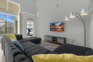 uma sala de estar com um sofá e uma TV em 5 Bedrooms 35 Bathrooms Windsor Palms 8017 Kp em Orlando