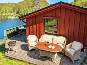 une cabine avec une table et des chaises sur une terrasse dans l'établissement Holiday Home Odden - Holmen by Interhome, à Lyngdal
