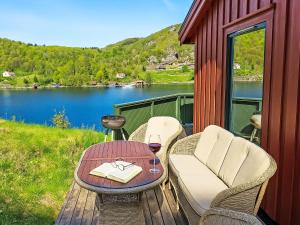 - une table et des chaises sur une terrasse avec vue sur le lac dans l'établissement Holiday Home Odden - Holmen by Interhome, à Lyngdal