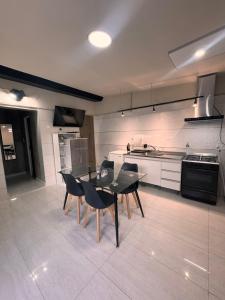 a kitchen with a black table and chairs in it at Pardo Mza in Godoy Cruz
