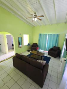 a living room with a couch and a ceiling fan at Ocean Heights in Arnos Vale