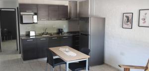 eine Küche mit einem kleinen Tisch und einem Kühlschrank in der Unterkunft Lo Nuestro in San Juan + 1 Foto