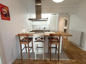 a kitchen with a wooden table and four chairs at Piso en San Sebastián cerca de Anoeta in Loyola