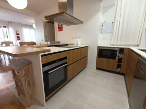 a kitchen with a stove top oven next to a table at Piso en San Sebastián cerca de Anoeta in Loyola +27 photos