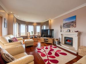 ein Wohnzimmer mit Kamin und Fernseher in der Unterkunft Holiday Home Benderloch House & Frobost Lodge by Interhome in Daliburgh