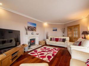 ein Wohnzimmer mit weißen Möbeln und einem Kamin in der Unterkunft Holiday Home Benderloch House & Frobost Lodge by Interhome in Daliburgh