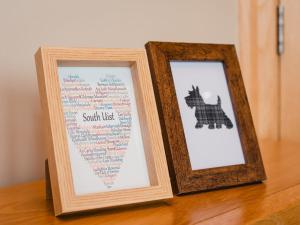 zwei Bilderrahmen stehen auf einem Holztisch in der Unterkunft Holiday Home Benderloch House & Frobost Lodge by Interhome in Daliburgh + 92 Fotos