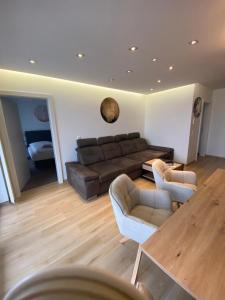 a living room with a couch and two chairs and a table at Appartement Silbermond in Schladming