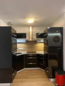a kitchen with black cabinets and a black refrigerator at Appartement Silbermond in Schladming