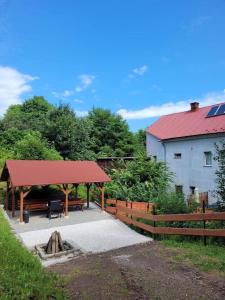 a picnic shelter with a red roof next to a building at Dom nad potokiem Opawa, na wyłączność, Karpacz, Opawa in Opawa