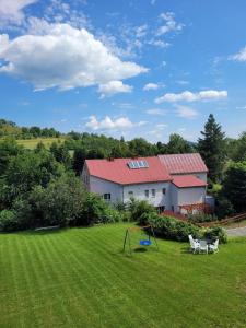 une maison avec une cour avec deux chaises et une aire de jeux dans l'établissement Dom nad potokiem Opawa, na wyłączność, Karpacz, Opawa, à Opawa