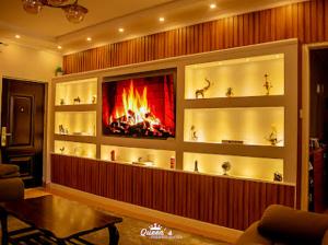 a living room with a fireplace on the wall at Queen's Premier Suites in Eldoret opposite Tamasha in Kisumu