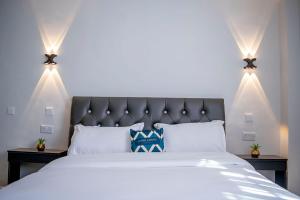 una camera da letto con un grande letto bianco con luci di Queen's Premier Suites in Eldoret opposite Tamasha a Kisumu