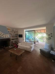ein Wohnzimmer mit einer weißen Couch und einem Tisch in der Unterkunft Villa a Capalbio in Carige Bassa