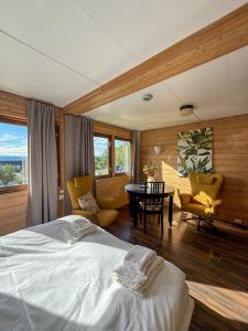 a bedroom with a bed and a table and chairs at Sandmoen Bed & Breakfast, Free Parking in Trondheim