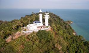 eine Insel mit einem Leuchtturm auf dem Ozean in der Unterkunft Glory Beach Resort PD, Fully Aircon Beatiful View Suite PortDickson in Port Dickson