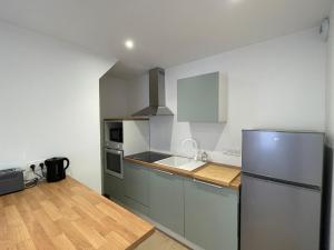 a kitchen with a refrigerator and a sink at L'Ecrin de Verdun in Verdun-sur-Meuse