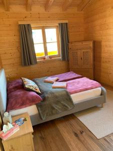 a bedroom with two beds in a log cabin at Chalet - Appartementhaus Alma in Haus im Ennstal