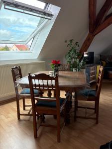 une salle à manger avec une table et des chaises et une fenêtre dans l'établissement Gîte le Nid, à Uffholtz