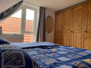 a bedroom with a bed with a blue comforter and a window at Baltic Joy in Damp