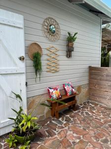 un banco sentado a un lado de una casa en Résidence Flores De Maria, en Le Marin