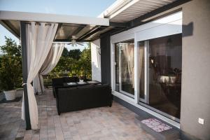 a screened in porch with a couch and curtains at Villa Lotta & Nolla in Mostar
