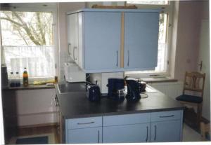 黑灵斯多夫Ferienwohnung In Gründerzeitvilla In Strandnähe的厨房配有白色橱柜和黑色台面