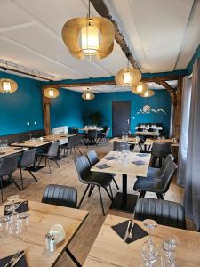 a restaurant with wooden tables and chairs and blue walls at Auberge de Pontgibaud in Lathuile +5 photos