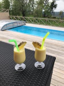 - deux boissons sur une table à côté d'une piscine dans l'établissement Ängshöjd, à Sandhem