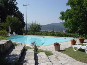ein Schwimmbecken in einem Garten mit einem Kreuz dahinter in der Unterkunft Ferienwohnung "Il Fienile" in Umbertide