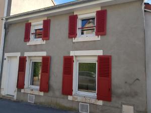 a building with red shutters on the side of it at L'Ecrin de Verdun in Verdun