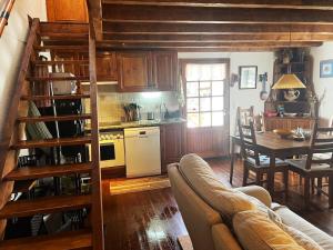 un soggiorno con un divano, un tavolo e una cucina di Escapada con encanto cerca de Porte-Puymorens y Andorra a Porta