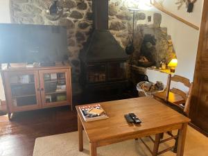 un soggiorno con tavolo in legno e camino di Escapada con encanto cerca de Porte-Puymorens y Andorra a Porta
