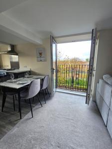 a room with a table and a kitchen with a sliding glass door at Pancinos Guest House Newmarket High Street in Newmarket +6 photos