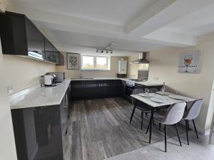 a large kitchen with a table and chairs in it at Pancinos Guest House Newmarket High Street in Newmarket